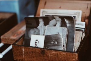 Brown box with lid open stuffed with black and white photographs of relatives and a baby. Self-awareness begins with knowing your lifelong patterns