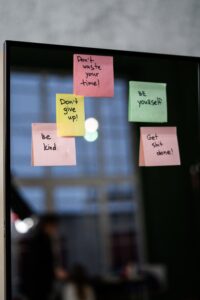 Sticky notes on mirror saying Get Shit Done, Don't give up, Don't waste your time, Be Yourself, Be Kind as a reminder to focus on goals